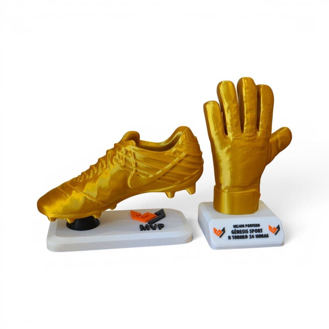Trofeos de bota de oro y guante de oro sobre una mesa